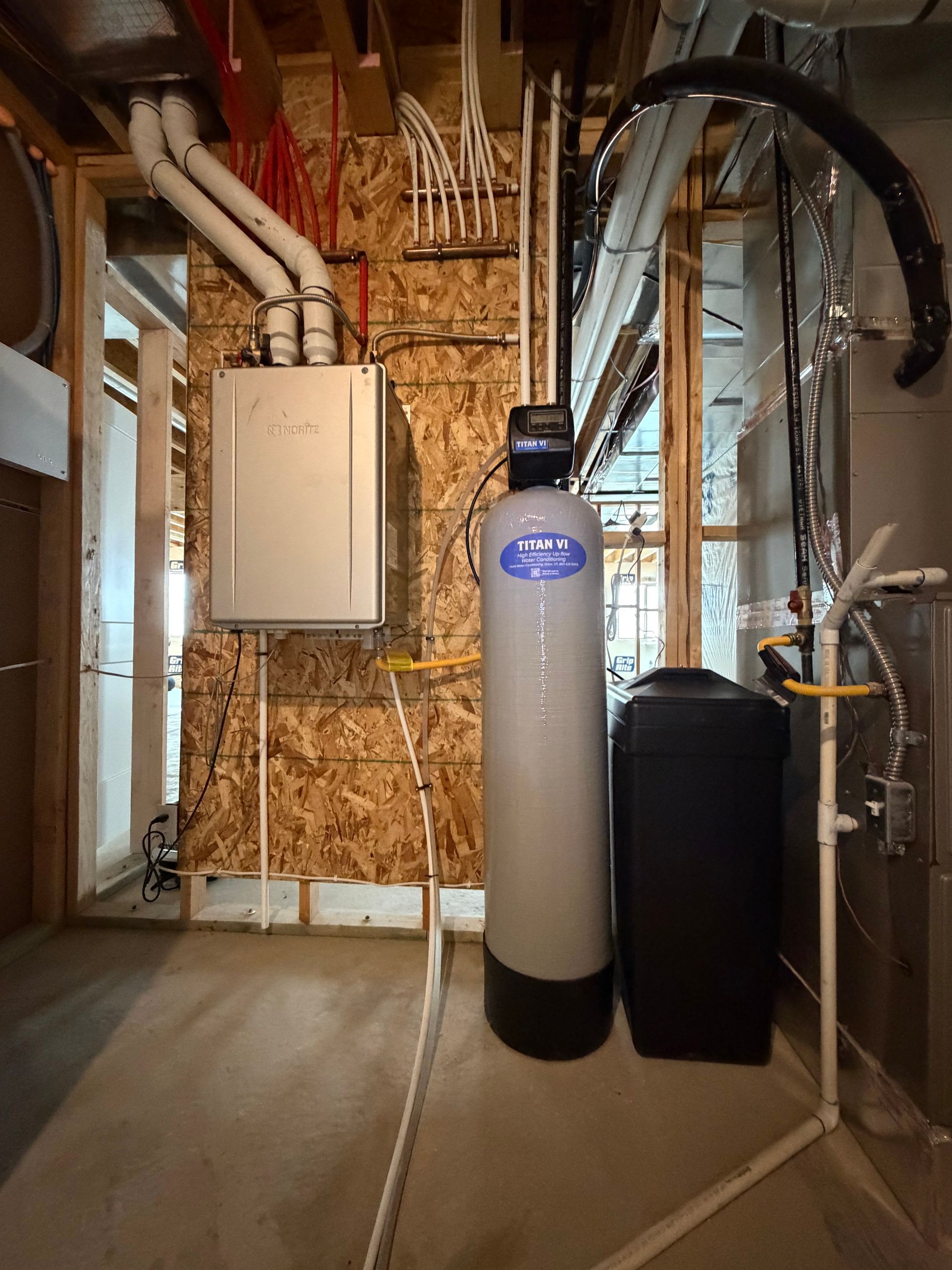 Basement utility area with water heater, furnace, exposed pipes, and electrical panel on unfinished walls