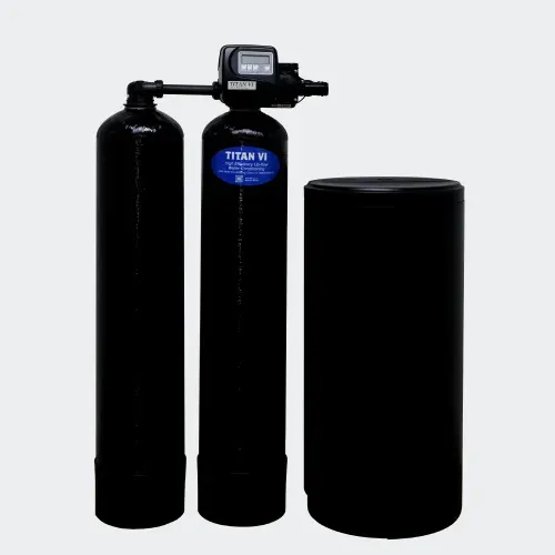 Water softener system in a basement, with a white control tank and gray brine tank beside exposed pipes.