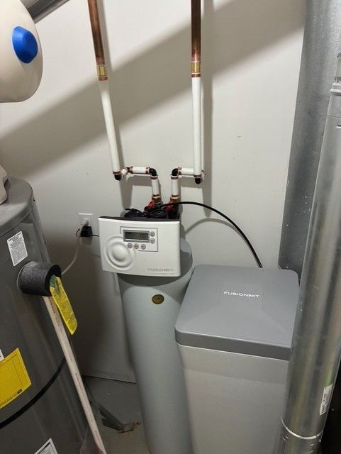 Gas water heater with copper pipes and a gray utility cabinet in a basement corner