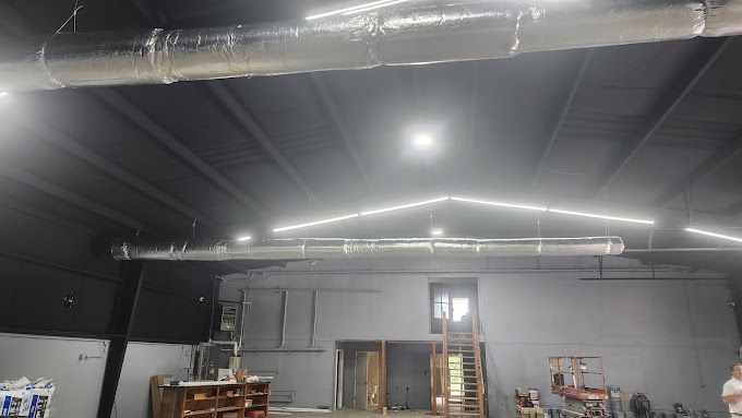 A large warehouse with a lot of lights on the ceiling.