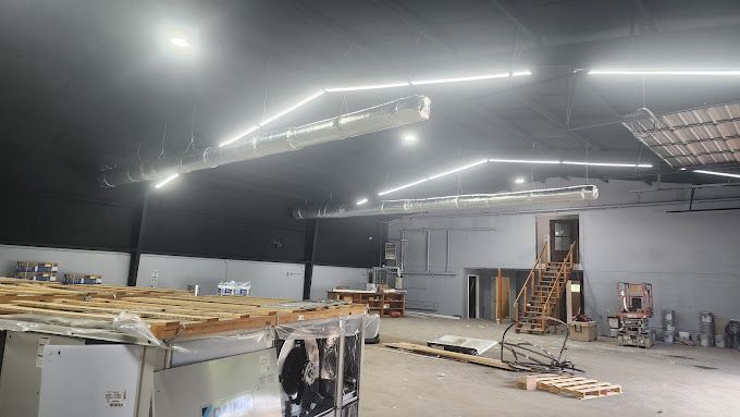 A large warehouse with a lot of lights on it at night.