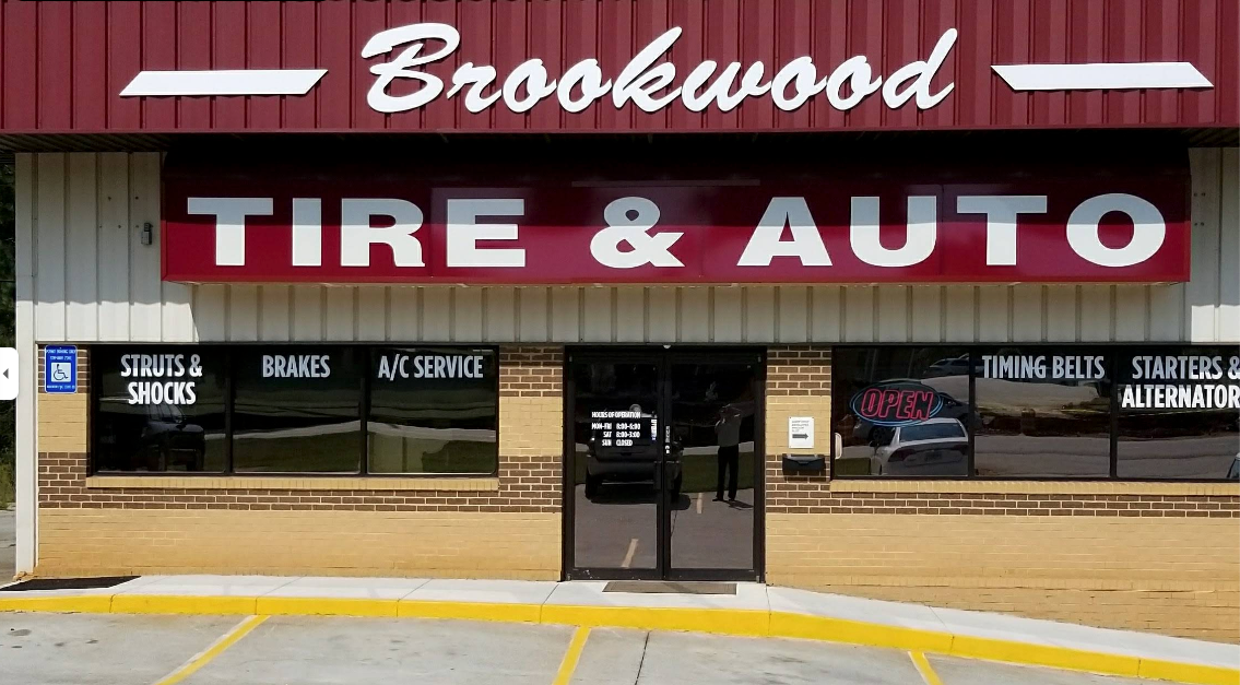 Brookwood Tire & Auto storefront with red awning and large white-and-red sign