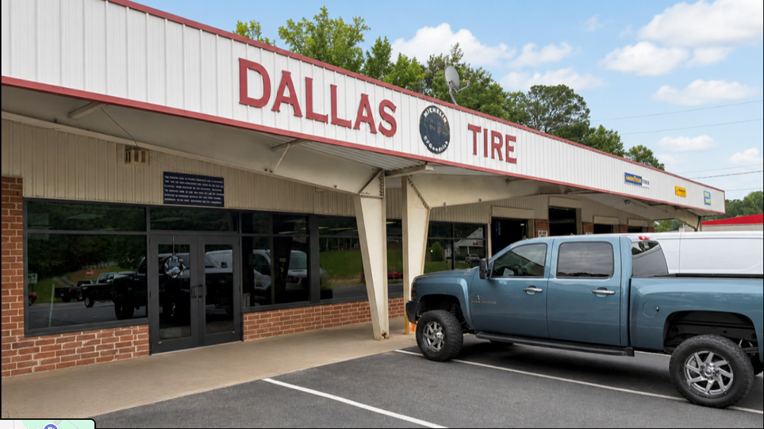 Dallas Tire storefront with a blue pickup truck parked outside