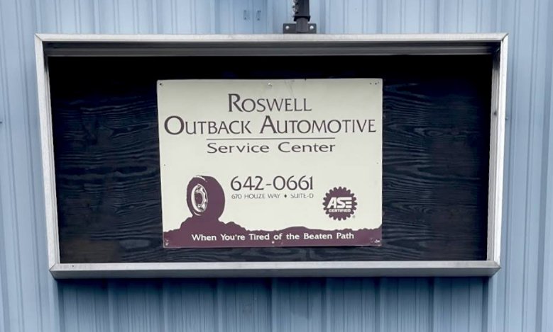 Roswell Outback Automotive Service Center sign on blue wooden wall with phone number 642-0661