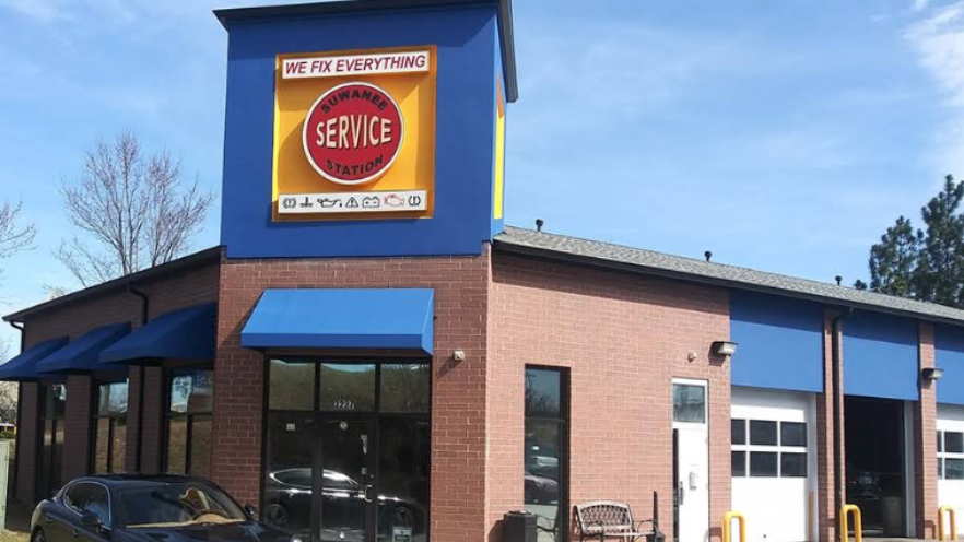 Exterior of a SERVPRO building with a red-and-yellow sign and blue trim under a clear sky