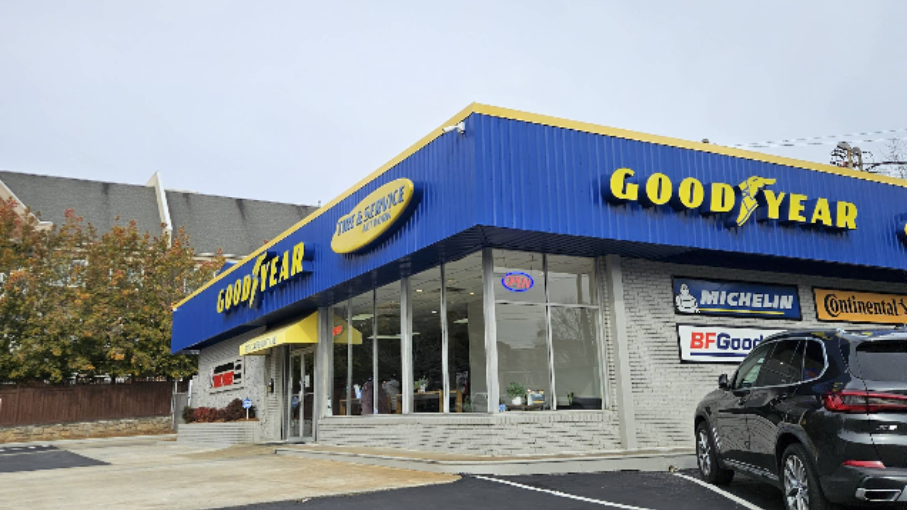 Goodyear auto service shop with blue awning and parked SUV outside