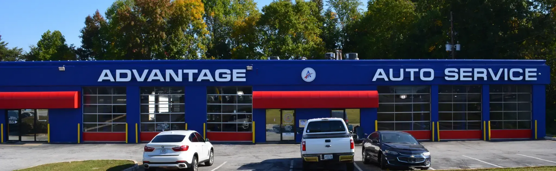 Advantage Auto Service storefront with blue sign, red awnings, and several cars parked outside