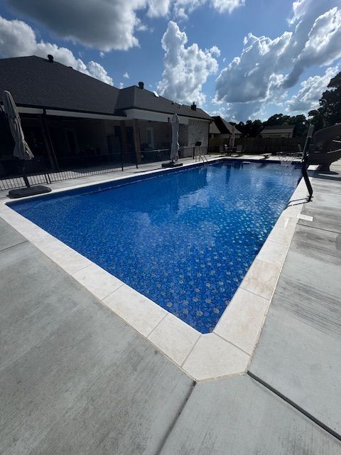 A large swimming pool surrounded by trees on a sunny day