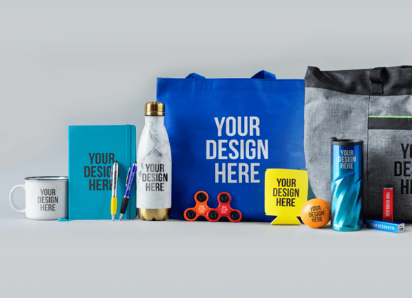 A collection of promotional merchandise including bags, mugs, pens, a water bottle, and a fidget spinner on a gray background.
