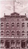 a black and white photo of a large brick building with a flag on top of it .