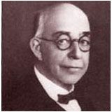 a black and white photo of a man wearing glasses and a bow tie .