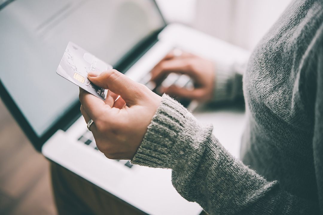 Person entering credit card information on a laptop.