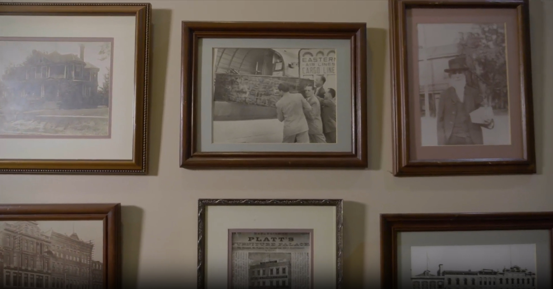 Framed black and white prints on a wall, showcasing historical scenes.