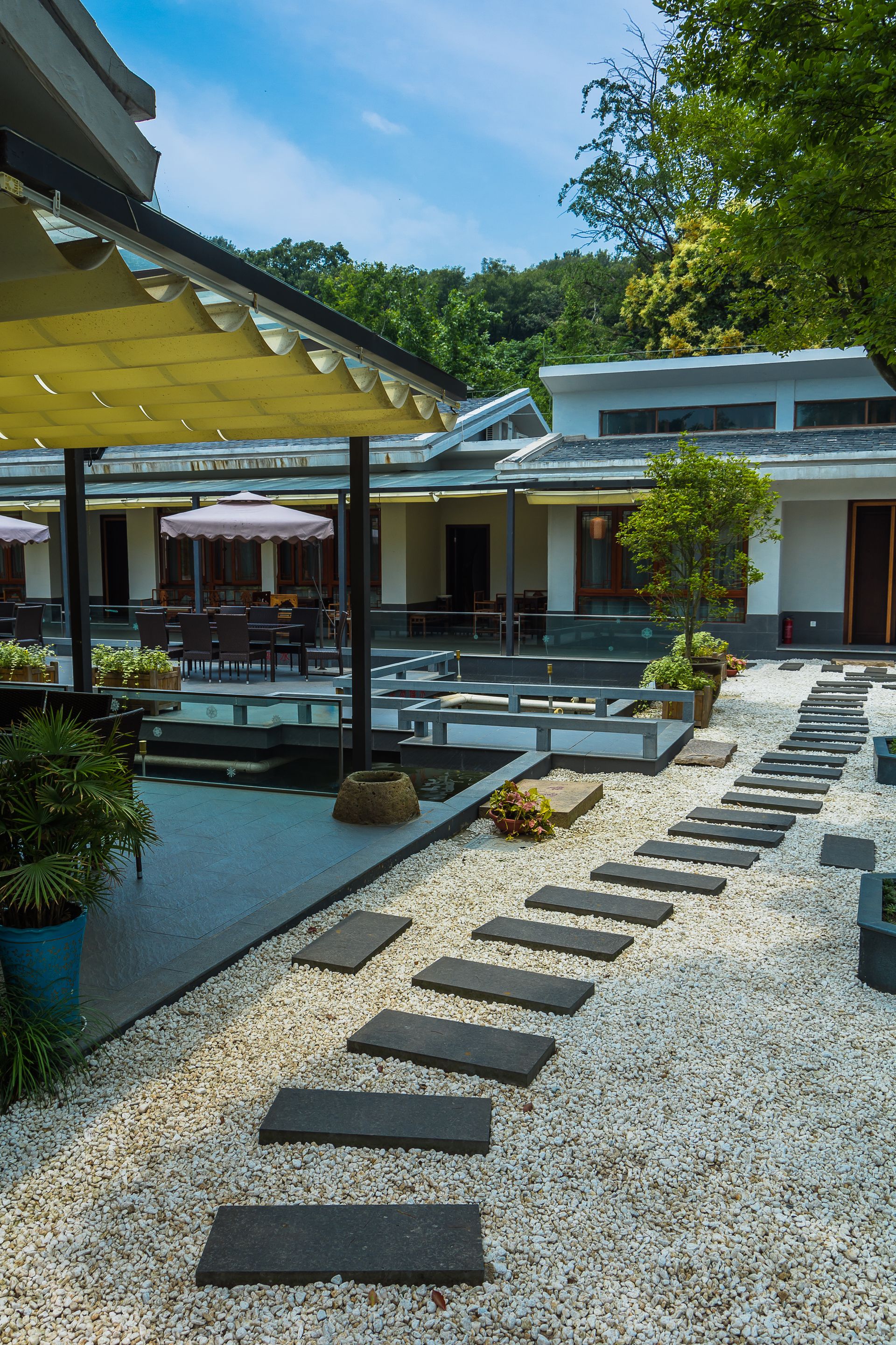 Stone path leads to a courtyard with white gravel