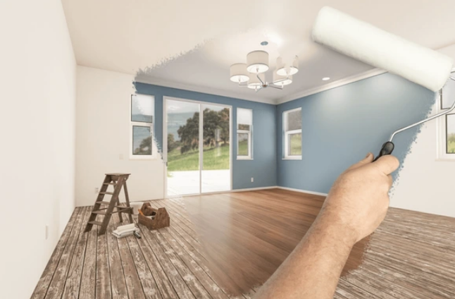 A person is painting a room with a paint roller.
