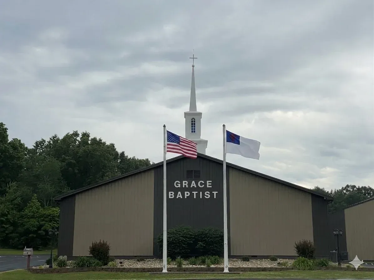 Grace Baptist sign on a tan building exterior at dusk