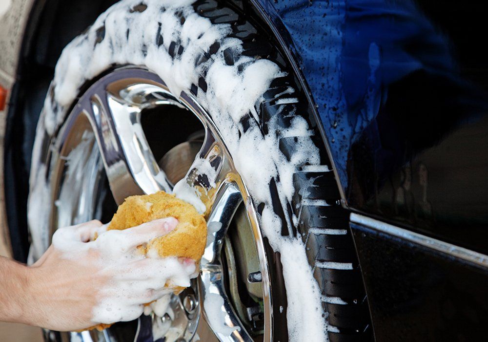 Person Cleaning The Car Wheels — Hutchinson, MN — Sullivan Mobile Detailing Person Cleaning The Car Wheels — Hutchinson, MN — Sullivan Mobile Detailing