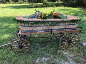 Decorative flower-filled wagon planter on grass in a sunny garden