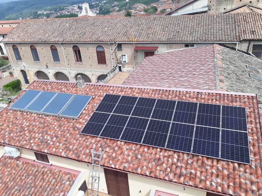 Ci sono molti pannelli solari sul tetto di un edificio.