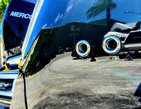 Side of a polished and waxed boat with the reflection of the ground