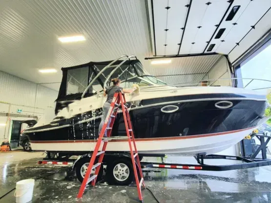 lady on a ladder washing a boat