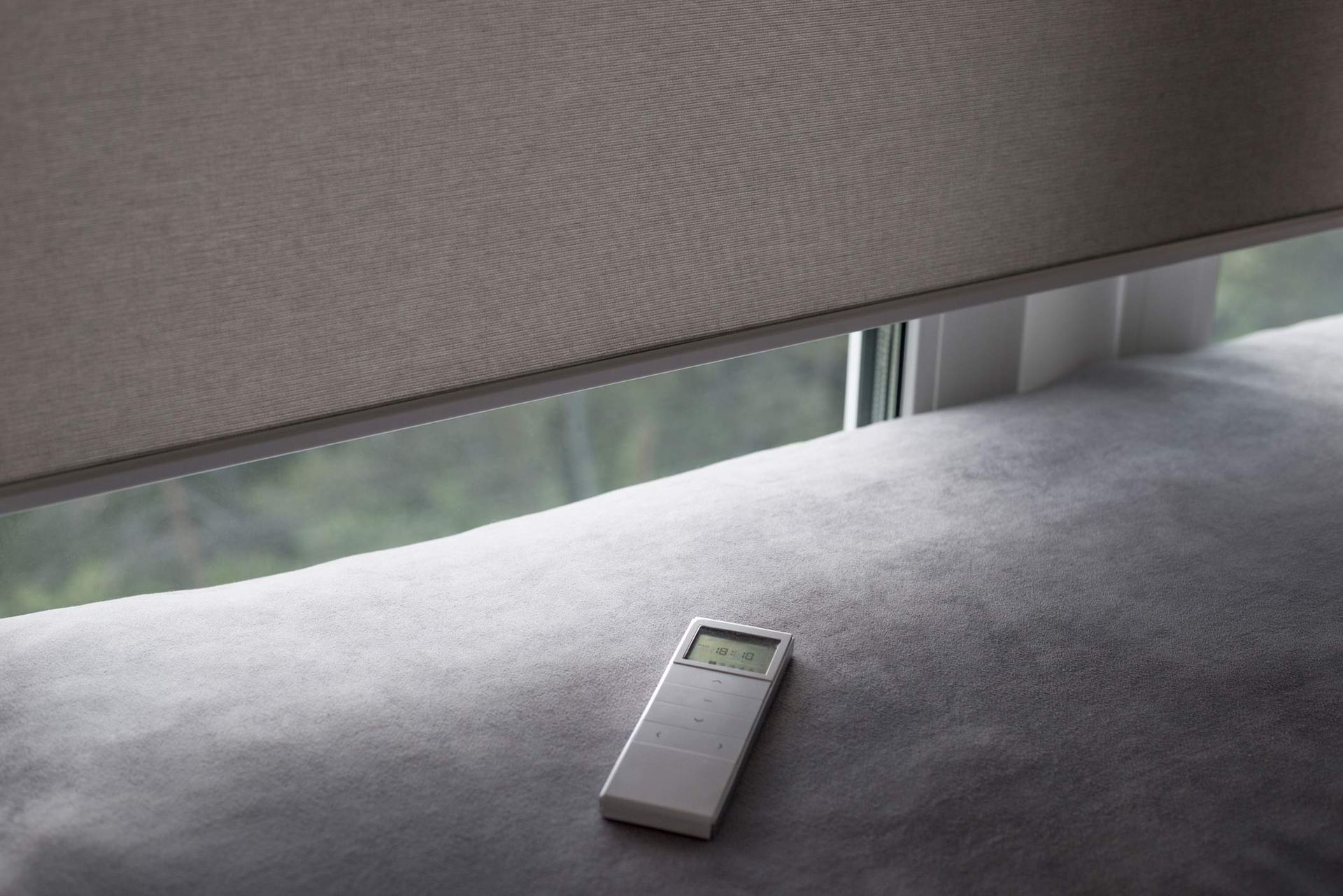 Closeup of remote representing motorized window treatment for smart home control. 