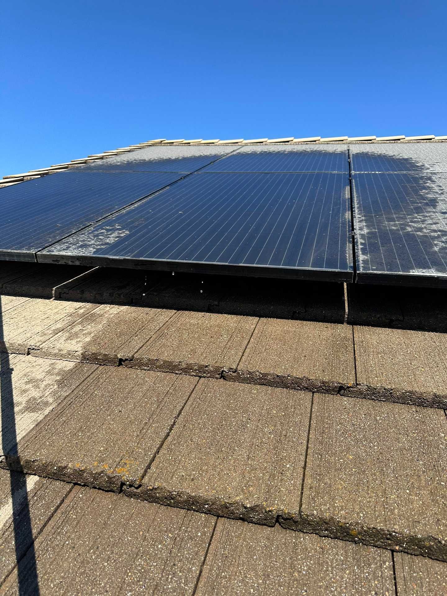 Solar panels on a rooftop under a clear blue sky.