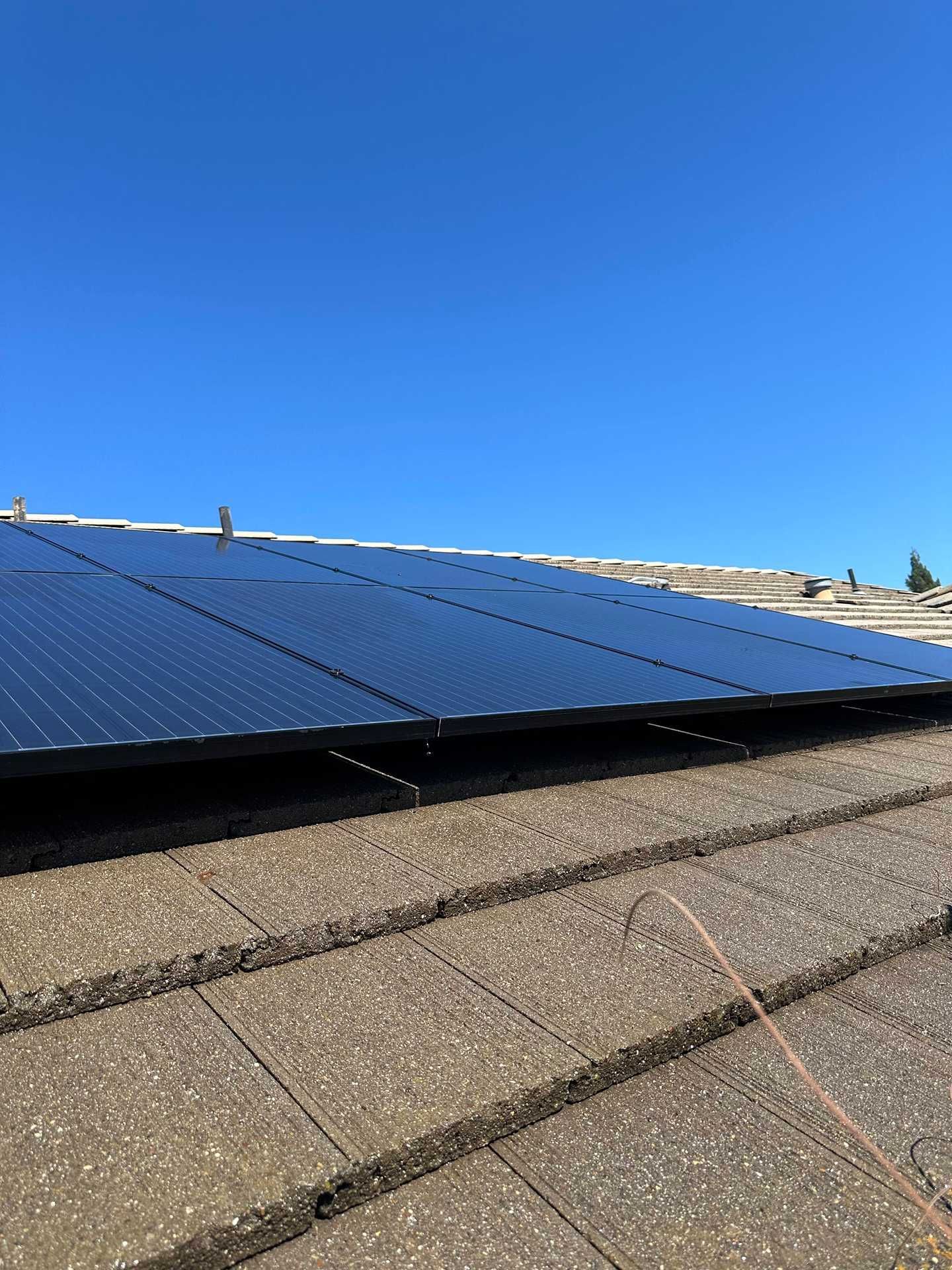 Solar panels on a rooftop under a clear blue sky.