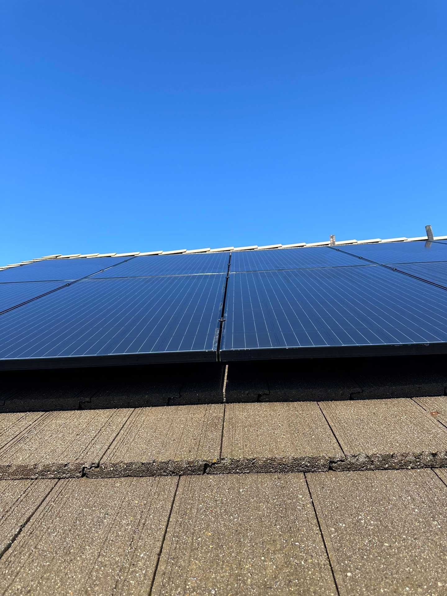 Solar panels on a rooftop under a clear blue sky.