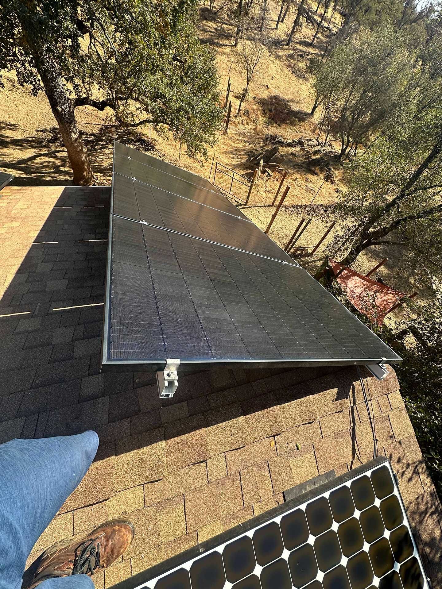 Solar panel mounted on a roof, with a smaller panel visible in the foreground.
