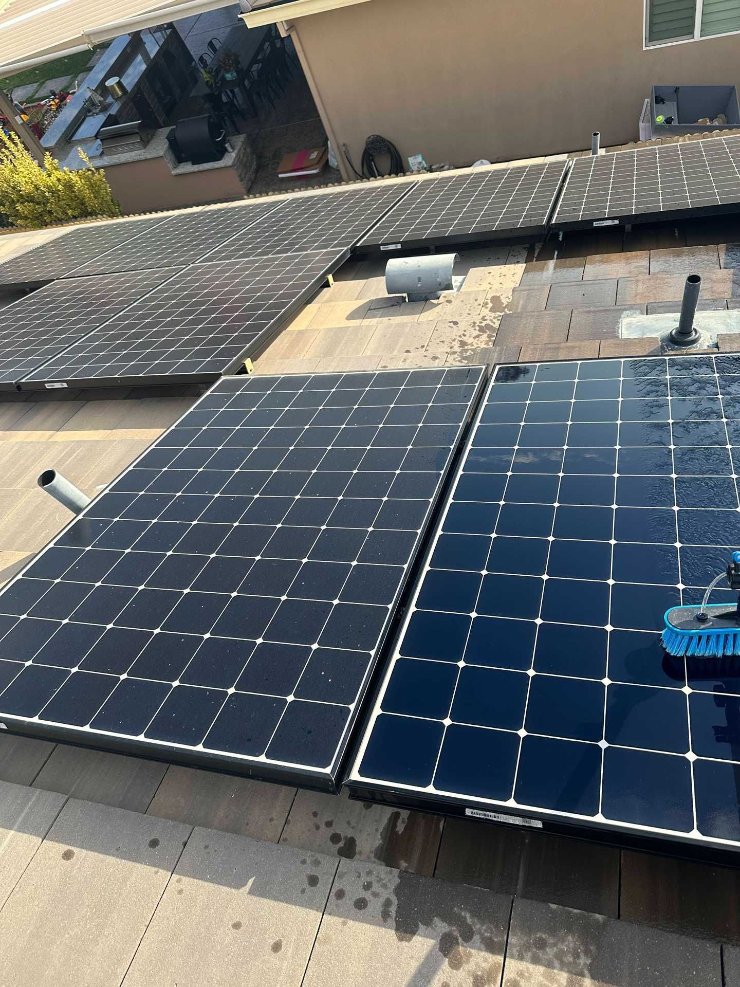 Solar panels installed on a rooftop, with two panels in the foreground and more panels behind.