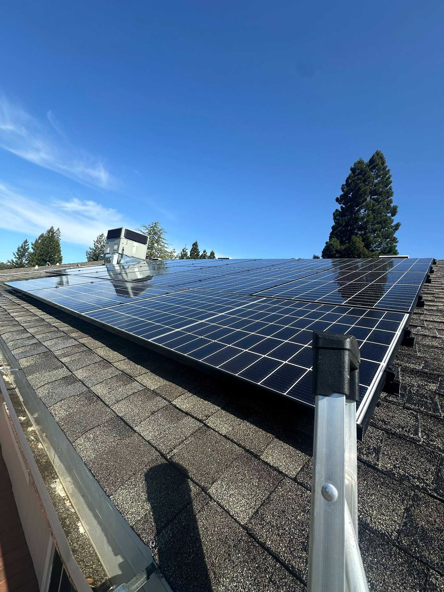 Solar panels on a sloped rooftop under a clear blue sky.
