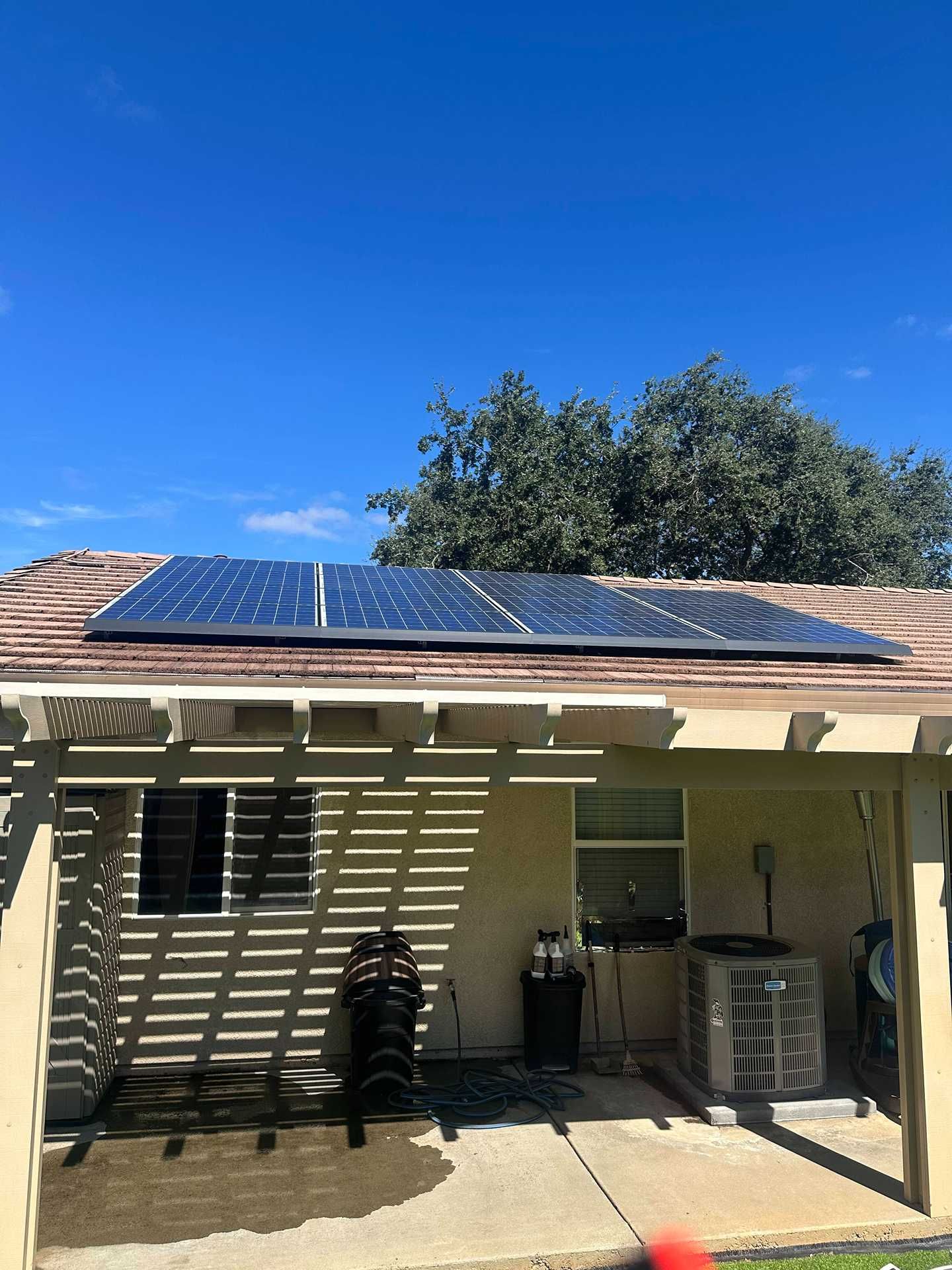 House patio with solar panels on the roof under a clear blue sky
