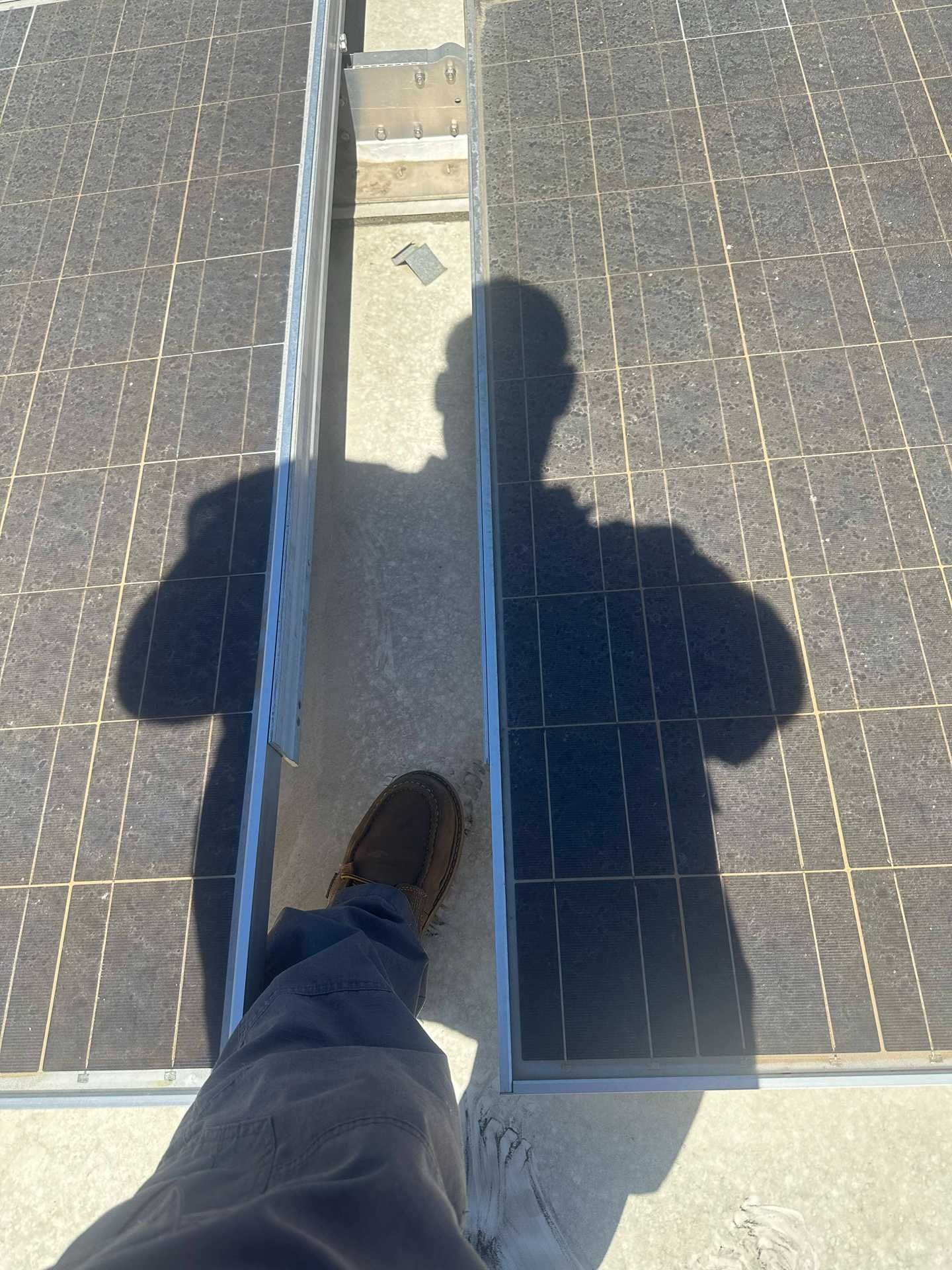 Person walking on solar panels with shadow cast on the panels.