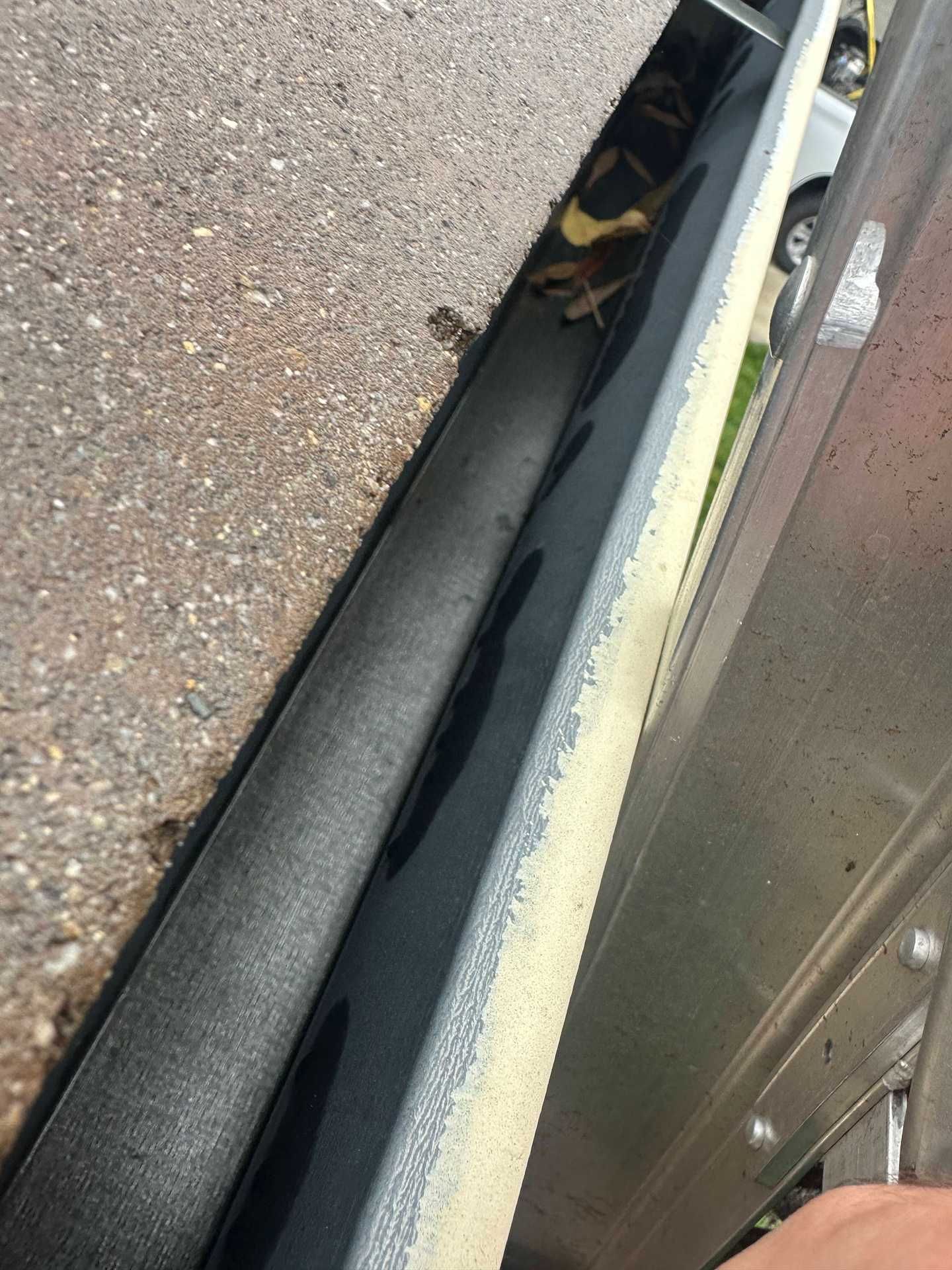 Close-up of a narrow gap beside a vehicle, showing a dark object wedged between metal surfaces.