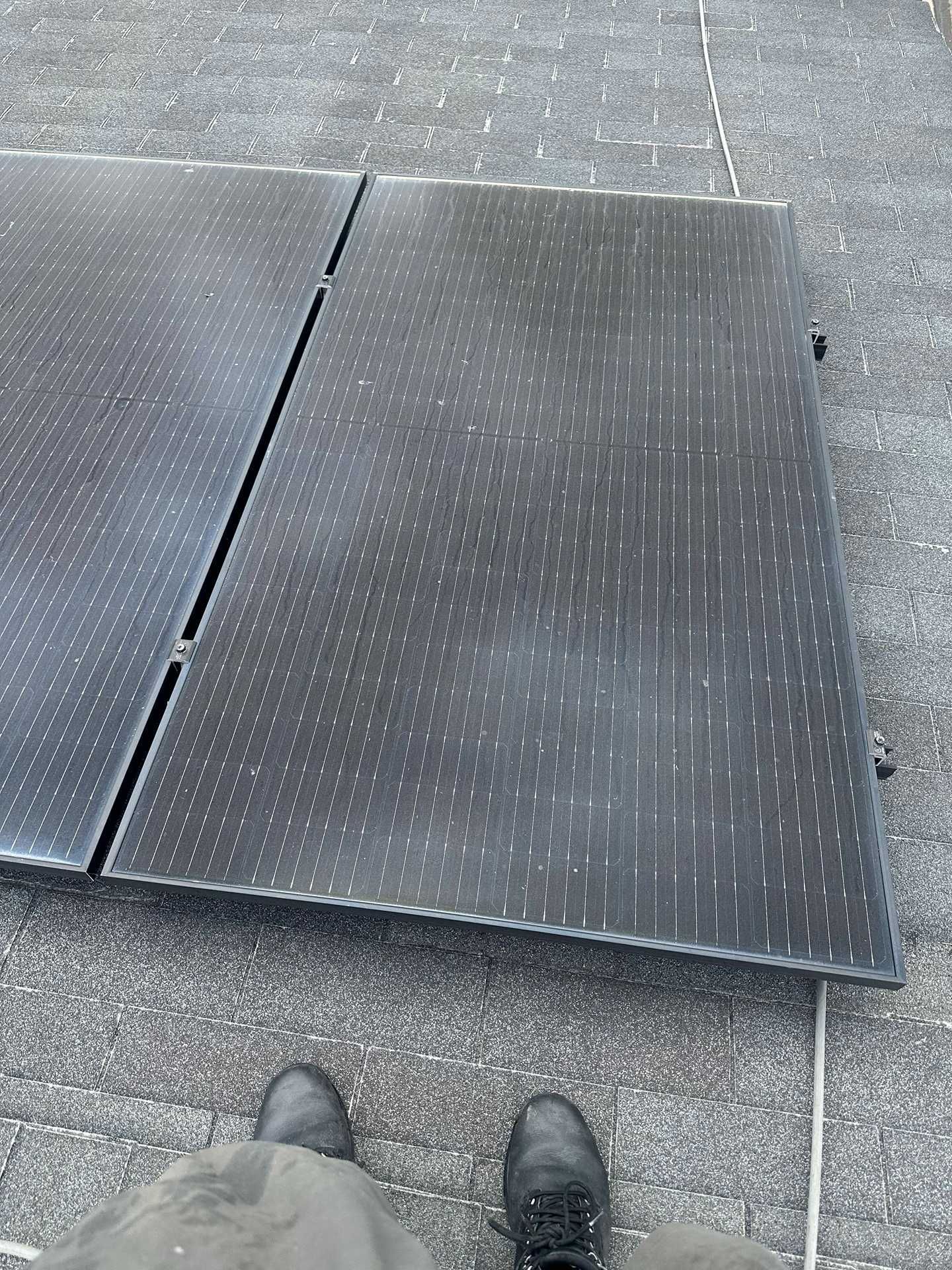Black metal ramp panel on pavement, viewed from above with feet visible at the bottom edge