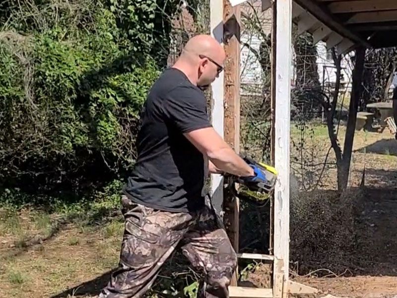 tearing down and old white wooden shed with aluminum siding
