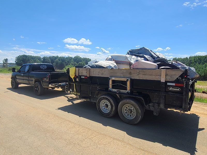 Trailer full of old mattresses and other junk