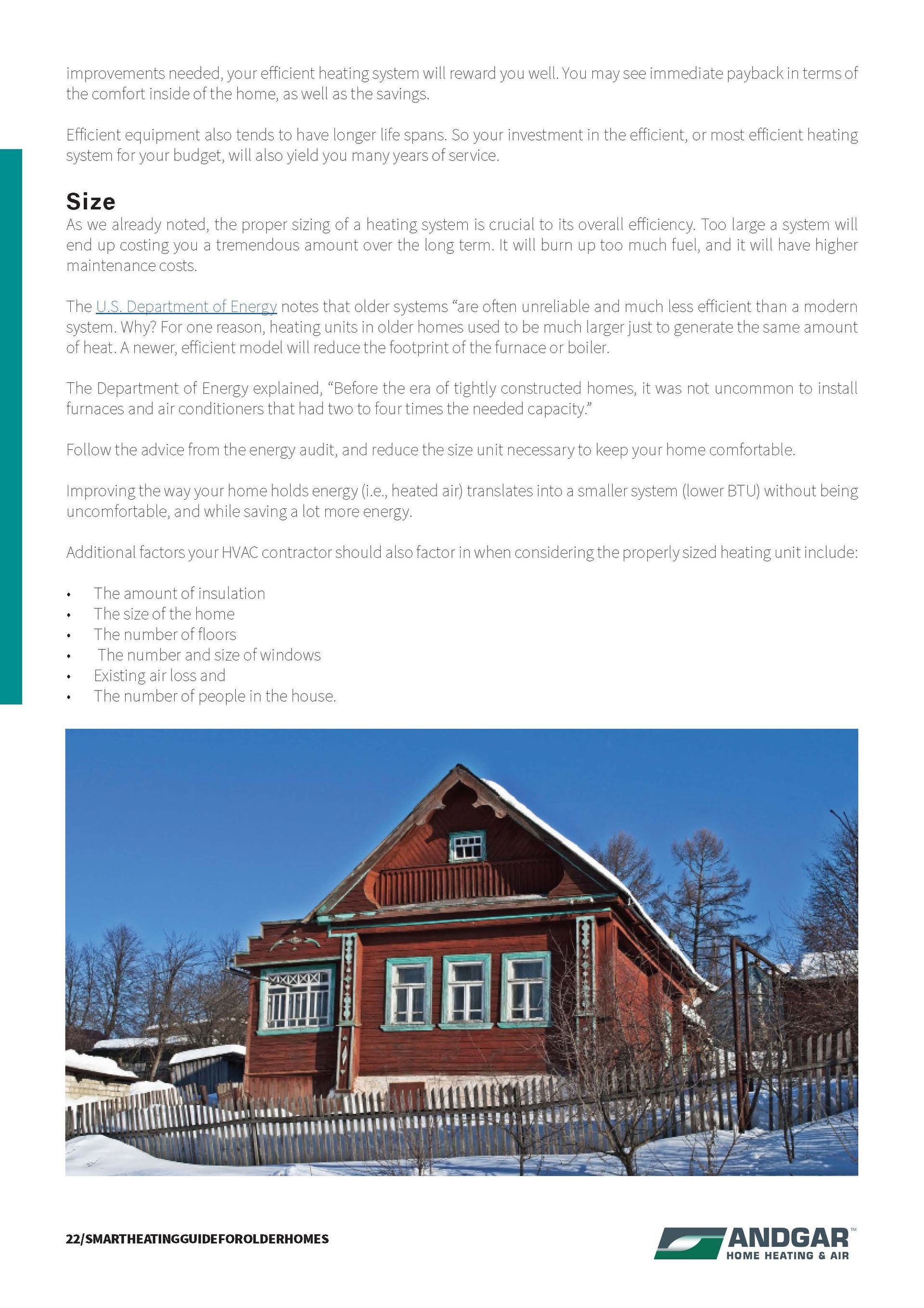 Red wooden house with a snowy fence under a clear blue sky