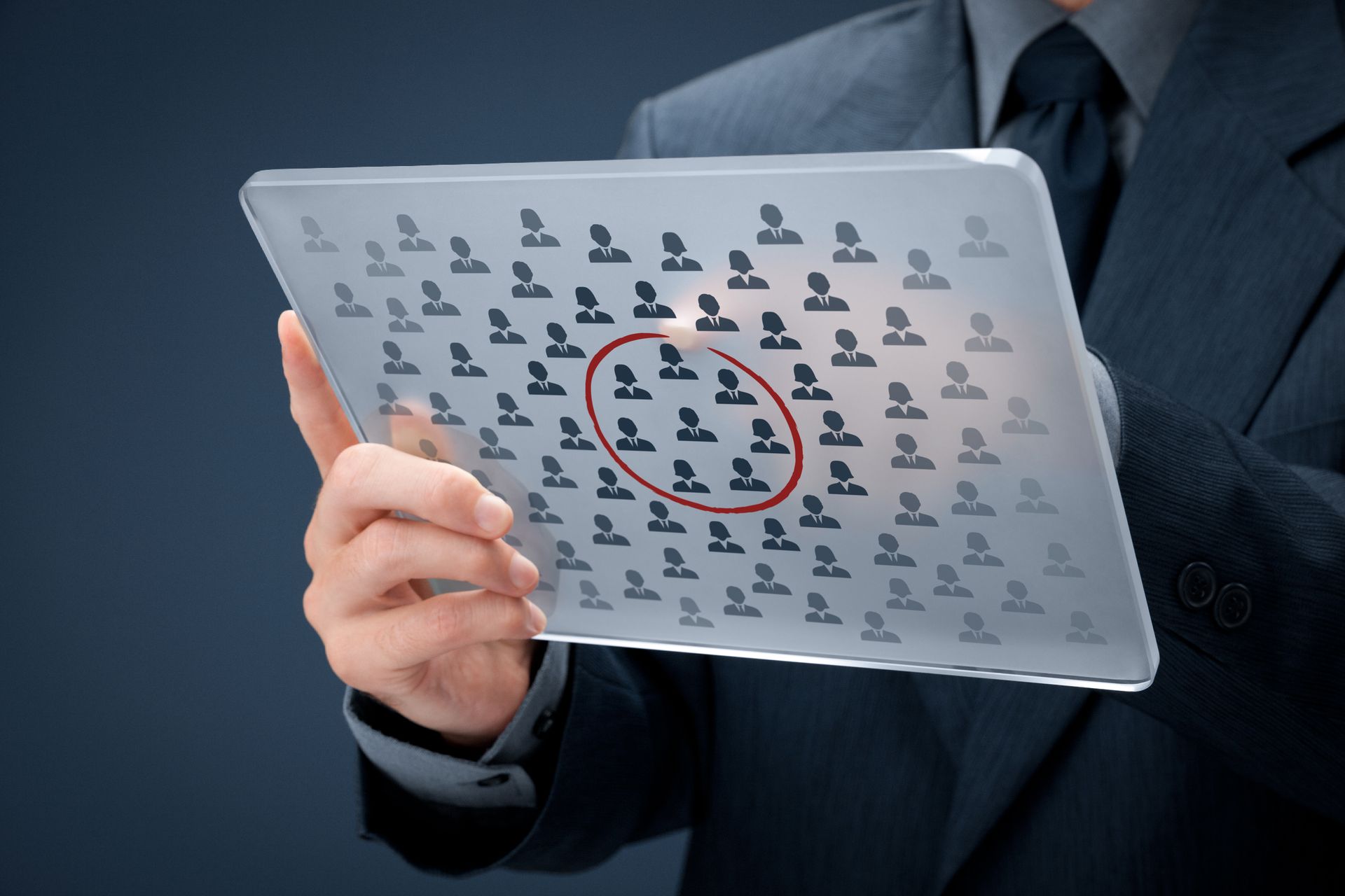 A man in a suit is holding a tablet with a red circle in the middle