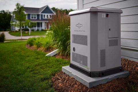 A generator is sitting on the side of a house.