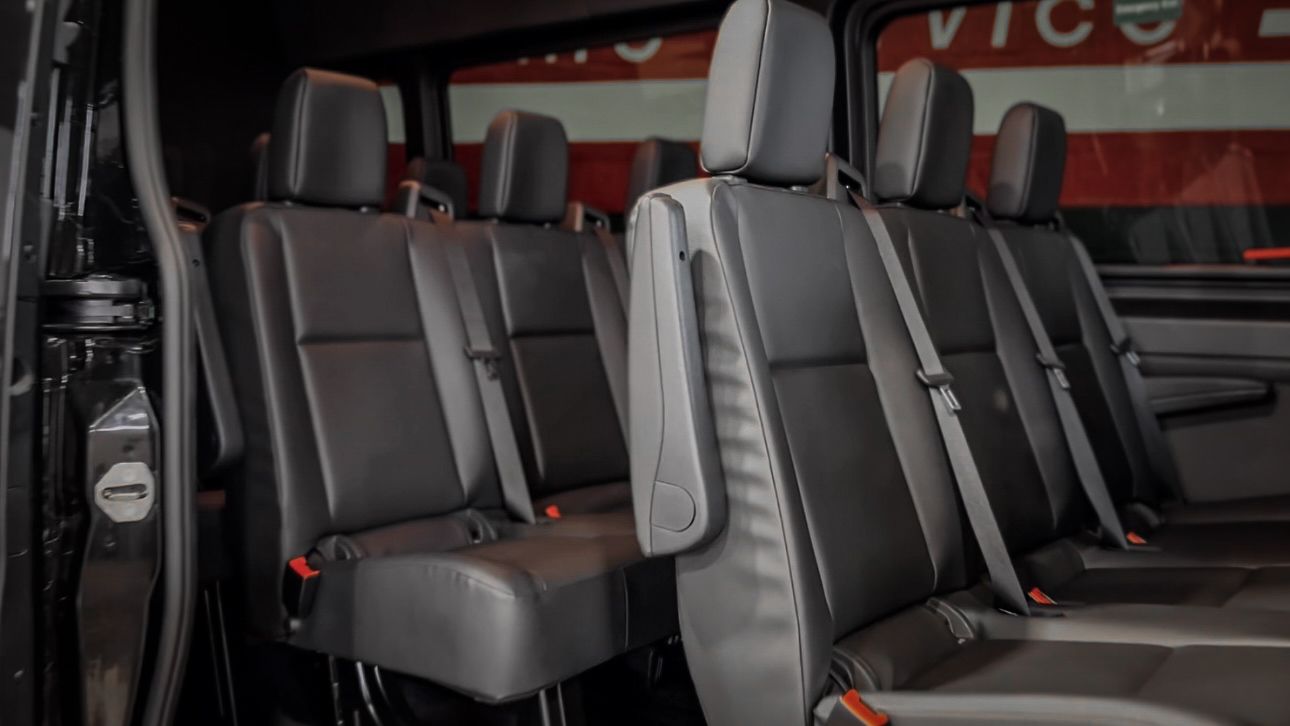 Rows of comfortable leather seats inside a Mercedes Sprinter van.