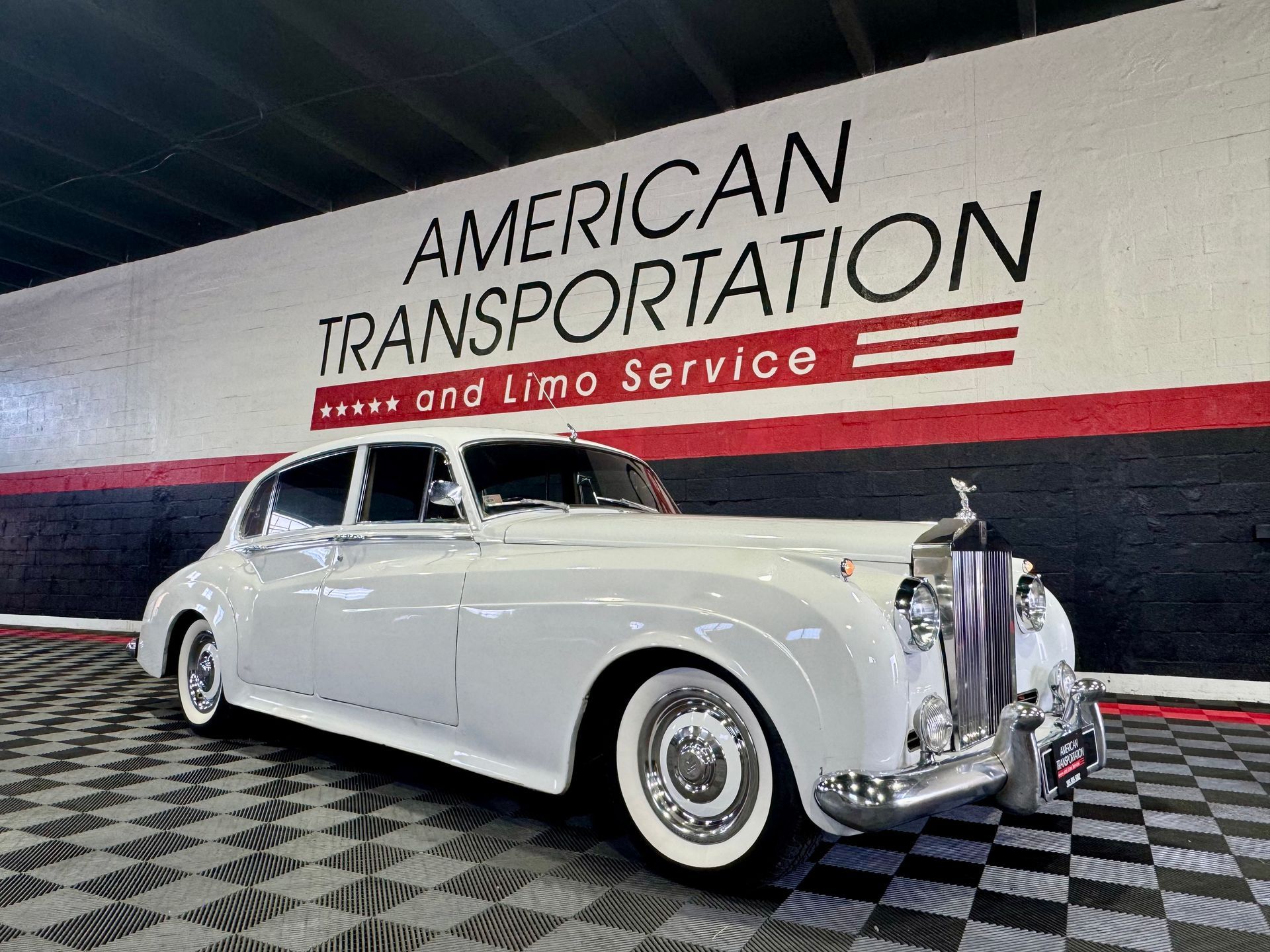 White Rolls-Royce Phantom parked in a showroom.