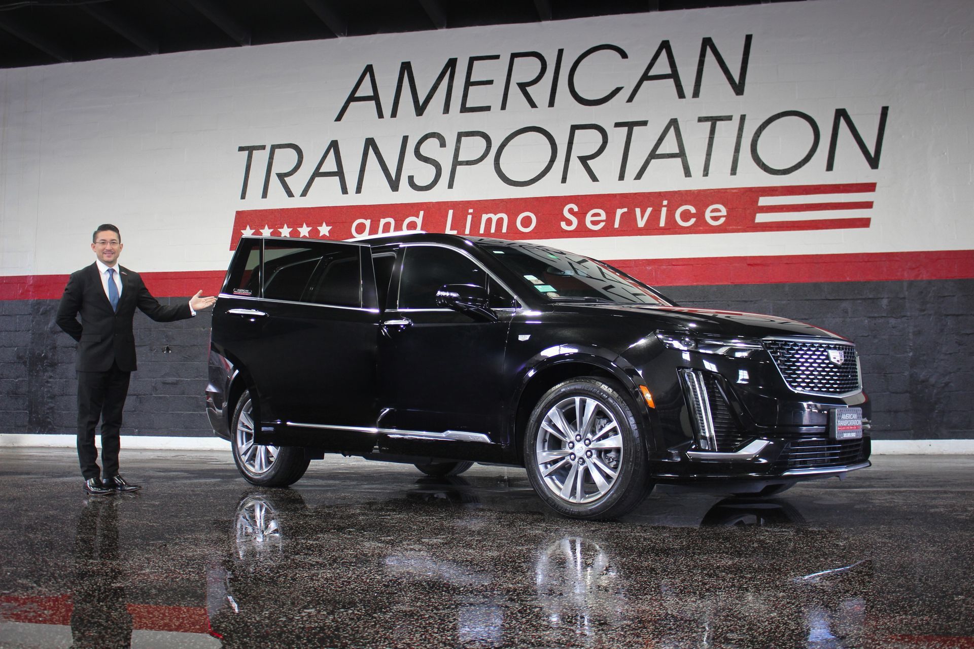 Man standing beside a black Cadillac Escalade used for private car service in Miami.