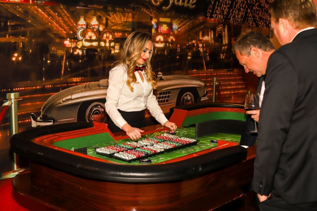 Small craps table with professional Croupier/dealer teaching the guests 