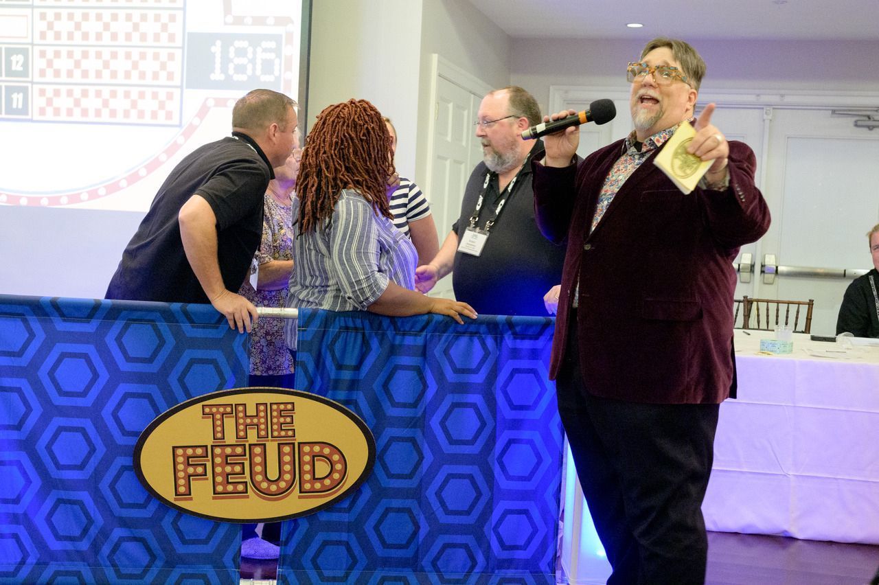 Our game show host entertains people at a team building event. 