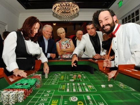 Professional croupiers entertaining guests at a craps table. 