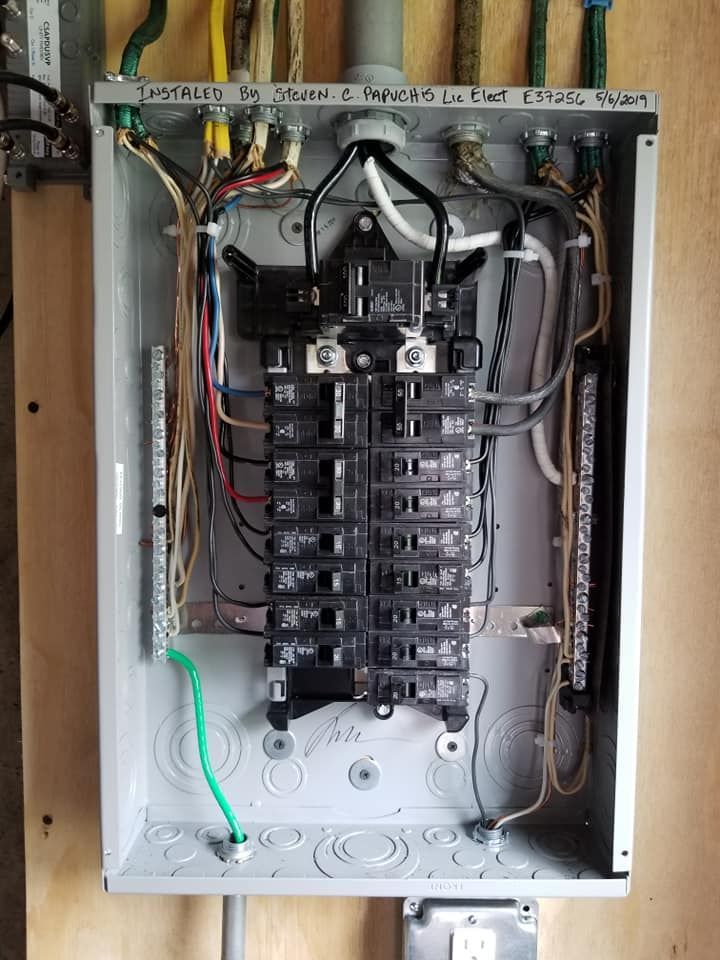 Open electrical breaker panel with wiring and circuit breakers inside a metal box