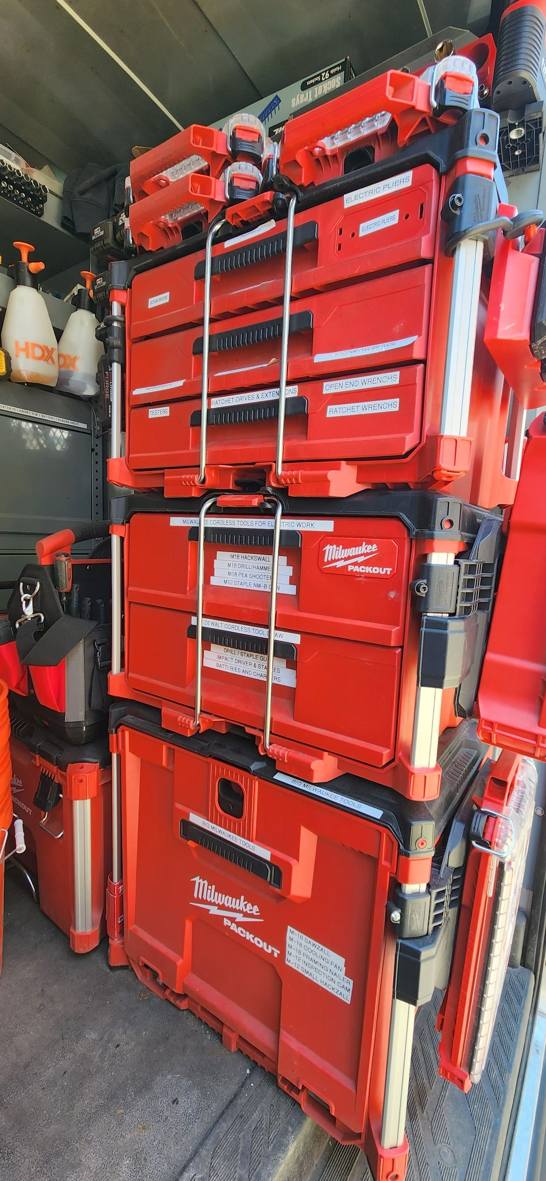 Stacked red rescue bags and tools stored inside a vehicle or equipment compartment.