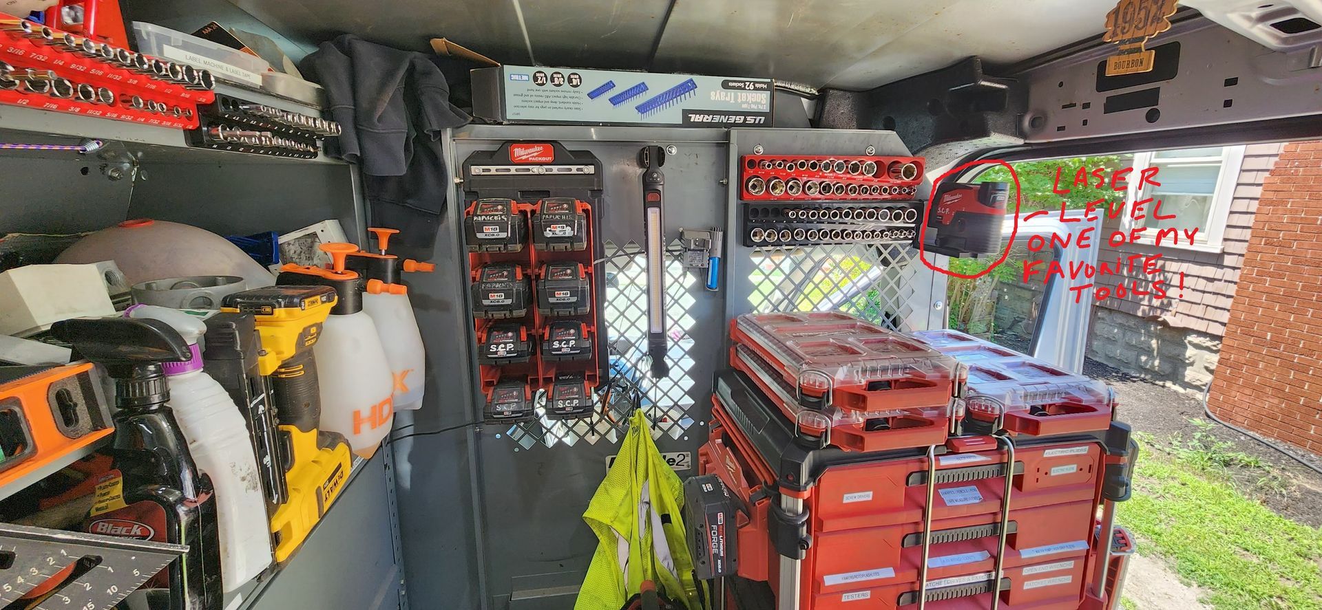 Cluttered workshop with tools, red storage crates, and equipment stacked inside a small garage.